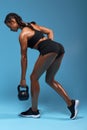 Full length back view photo, slim girl working out with kettlebell