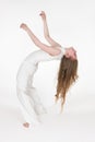 Full length barefoot young woman with eyes closed having fun while bending over backwards on white Royalty Free Stock Photo