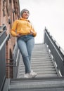 Full-length beautiful trendy girl standing and looks to side. Young woman model posing against blurred background Royalty Free Stock Photo