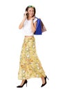 Full length beautiful young asian woman with shopping bags walking and talking on mobile phone Royalty Free Stock Photo