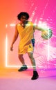 Full length of biracial player dribbling basketball by illuminated plants and square, copy space