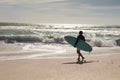 Full length of biracial senior man carrying surfboard walking towards waves in sea at beach Royalty Free Stock Photo