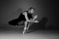 Full length black and white photo of beautiful young blonde ballet dancer in a black dress and pointes in complex pose Royalty Free Stock Photo