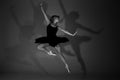 Full length black and white photo of beautiful young blonde ballet dancer in a black dress and pointes in complex pose Royalty Free Stock Photo