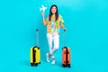 Full length body cadre of optimistic cute korean girl hold paper airplane lowcost transport luggage isolated on