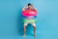 Full length body photo playful childish man going wearing colorful rubber circles laughing isolated on bright blue color