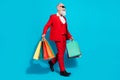Full length body size photo aged man keeping bags shopping mall walking forward isolated vivid blue color background