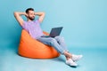 Full length body size photo of bearded programmer chilling during break in orange beanbag isolated on vivid blue color