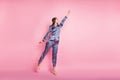 Full length body size photo of brunette in blue pajama jumping imagine keeping umbrella isolated on pastel pink color