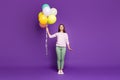 Full length body size photo of cheerful charming gorgeous fascinating girl holding balloons filled with helium isolated