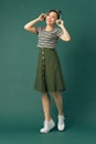 Full length body size photo of dancing girl imagining herself at disco while isolated with green background