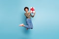 Full length body size photo of excited crazy cheerful nice positive ecstatic woman wearing jeans denim holding giftbox Royalty Free Stock Photo