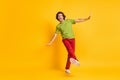 Full length body size photo funny carefree man wearing red pants sneakers dancing pretending plane isolated vivid yellow Royalty Free Stock Photo