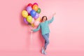 Full length body size photo girl laughing keeping pile of balloons birthday party isolated pastel pink color background