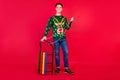 Full length body size photo happy guy in ugly sweater smiling with sledges isolated bright red color background