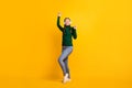 Full length body size photo overjoyed girl listening music wearing headphones dancing isolated on bright yellow color