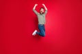 Full length body size photo of rejoicing happy man jumping with victory while with red background