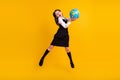 Full length body size photo schoolgirl amazed jumping with globe on geography isolated vivid yellow color background