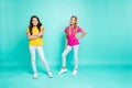 Full length body size photo of two young models posing in front of camera wearing pink and yellow t-shirts while Royalty Free Stock Photo