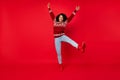 Full length body size photo woman smiling careless childish wearing sweater isolated bright red color background