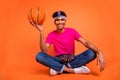 Full length body size photo of young man with piercing earrings holding ball in pink t-shirt isolated vibrant orange Royalty Free Stock Photo