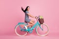 Full length body size profile side view of attractive cheerful girl riding vintage blue bike having fun  on pink Royalty Free Stock Photo