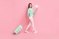 Full length body size profile side view of cheerful girl traveler going holding in hand paper plane isolated on pink Royalty Free Stock Photo