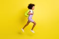 Full length body size profile side view of cheerful wavy-haired girl jumping running to lesson isolated over bright Royalty Free Stock Photo