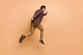 Full length body size rear back behind view of attractive motivated man jumping running late hour isolated over beige Royalty Free Stock Photo