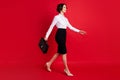 Full length body size side profile photo business woman walking forward carrying leather bag smiling isolated vivid red Royalty Free Stock Photo