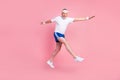 Full length body size side profile photo senior man jumping high running fast in sportswear isolated pastel pink color Royalty Free Stock Photo