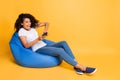 Full length body size turned photo of cheerful positive curly wavy trendy stylish overjoyed girl playing video games Royalty Free Stock Photo