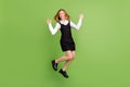 Full length body size view of attractive cheerful carefree girl jumping dancing over green color background