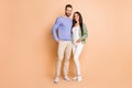 Full length body size view of attractive cheerful couple soulmates embracing isolated over beige pastel color background