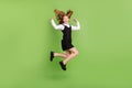 Full length body size view of attractive cheerful girl jumping having fun good mood over green color background