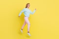 Full length body size view of attractive cheerful girl jumping walking wearing cozy clothes isolated over bright yellow