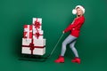 Full length body size view of attractive cheerful girl wearing Santa look carrying many giftboxes isolated over green