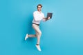 Full length body size view of attractive cheerful man jumping using laptop it expert isolated over bright blue color