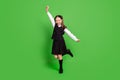 Full length body size view of attractive cheerful schoolgirl dancing rejoicing isolated over bright green color Royalty Free Stock Photo