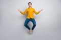 Full length body size view of attractive dreamy focused calm man jumping meditating isolated over grey color background