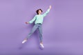 Full length body size view of attractive funny cheerful girl jumping holding invisible parasol isolated over violet Royalty Free Stock Photo