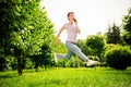 Full length body size view of attractive trendy cheerful girl jumping talking on phone on fresh air outdoors Royalty Free Stock Photo