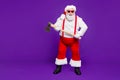 Full length body size view of his he nice funky hilarious cheery glad cheerful bearded thick fat dangerous Santa holding