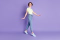 Full length body size view of lovely cheerful girl jumping going wearing cozy clothes isolated over violet color