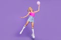 Full length body size view of lovely cheerful girl jumping holding ball celebratory isolated over vivid purple violet