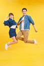 Full length body size view of nice attractive lovely cheerful cheery couple jumping up in air isolated over yellow background