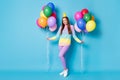 Full length body size view of pretty cheerful girl holding in hands helium balls celebratory isolated bright blue color