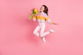 Full length body size view of pretty trendy cheerful girl jumping holding tulips good mood isolated over pink pastel Royalty Free Stock Photo