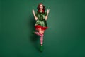 Full length body size view of pretty trendy cheerful girl jumping showing v-sign  over green color background Royalty Free Stock Photo