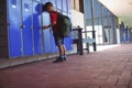 Full length of boy leaning on lockers in corridor